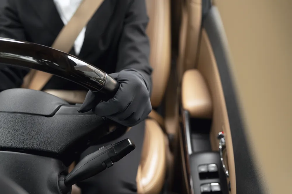 Chauffeur privé en tenue professionnelle au volant pour transport haut de gamme et service discret